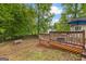 Spacious backyard with a wooden deck, leafy trees, an umbrella, and a fence at 75 Mcintosh Estates Dr, Sharpsburg, GA 30277