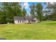 A single-story home with green lawn, neutral siding, black shutters, and a covered front porch at 75 Mcintosh Estates Dr, Sharpsburg, GA 30277