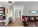 Hallway with wood floors leads to the bathroom and leather sofa at 75 Mcintosh Estates Dr, Sharpsburg, GA 30277