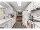 Galley kitchen featuring white cabinets, stainless appliances, and a view into the dining area at 75 Mcintosh Estates Dr, Sharpsburg, GA 30277