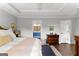 Main bedroom featuring a tray ceiling, wood floors, and a view into the bathroom at 75 Mcintosh Estates Dr, Sharpsburg, GA 30277
