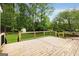 Expansive wooden back deck with black metal railing overlooks the private backyard and lush trees at 100 Hartford Pl, Fayetteville, GA 30214