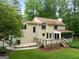 Backyard featuring a wooden deck, stone patio, screened-in porch, lush green lawn, and mature trees at 100 Hartford Pl, Fayetteville, GA 30214