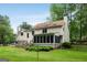 Expansive backyard featuring a screened-in porch, wooden deck, lush green lawn, and mature trees at 100 Hartford Pl, Fayetteville, GA 30214