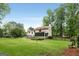Spacious backyard with lush lawn, mature trees, privacy fence, and back deck of home at 100 Hartford Pl, Fayetteville, GA 30214