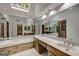 Elegant bathroom featuring dual sinks, a soaking tub, mirrored wall, and natural light from skylight at 100 Hartford Pl, Fayetteville, GA 30214