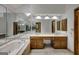 Bright bathroom features a soaking tub with a large mirror, and double sink vanity at 100 Hartford Pl, Fayetteville, GA 30214