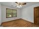 Bedroom featuring a wood-trimmed window, ceiling fan and hardwood floors at 100 Hartford Pl, Fayetteville, GA 30214