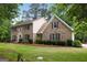 Beautiful two-story brick home featuring mature trees and professionally landscaped front yard at 100 Hartford Pl, Fayetteville, GA 30214