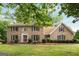 Charming two-story brick home with lush green lawn, mature trees, and well-maintained landscaping at 100 Hartford Pl, Fayetteville, GA 30214