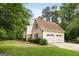 Charming home with a two-car garage, lush landscaping, mature trees, and well-maintained lawn at 100 Hartford Pl, Fayetteville, GA 30214
