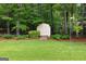 A storage shed with double doors is nestled among the trees and lush landscaping at 100 Hartford Pl, Fayetteville, GA 30214