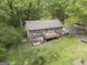 Aerial view of a brick home with wooden deck surrounded by landscaping and green grass at 165 White Rose Ln, Temple, GA 30179