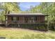 Charming brick home featuring a cozy front porch, mature landscaping, and a welcoming entryway at 165 White Rose Ln, Temple, GA 30179