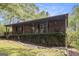 Brick ranch home featuring a cozy front porch, lush ivy, and well-maintained rock landscaping at 165 White Rose Ln, Temple, GA 30179