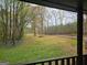 View from porch overlooking expansive backyard, mature trees, and a tranquil, natural setting at 165 White Rose Ln, Temple, GA 30179
