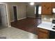 View of the kitchen cabinets, and entryway to the living room with hardwood floor and a ceiling fan at 3875 Grand Prix St, Cumming, GA 30041