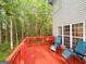 A quaint red deck with outdoor seating, perfect for enjoying wooded backyard views through adjacent windows at 80 Jacksons Vly, Sharpsburg, GA 30277