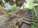 View of home's backyard with stairs leading up to a deck and abundant landscaping at 80 Jacksons Vly, Sharpsburg, GA 30277