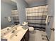 Main bathroom includes a shower/tub, toilet and sink with decorative mirror and fixtures at 80 Jacksons Vly, Sharpsburg, GA 30277