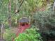 Secluded gazebo offers a tranquil escape surrounded by lush greenery, accessible via a red walkway and bridge at 80 Jacksons Vly, Sharpsburg, GA 30277