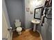 Charming half bathroom with a pedestal sink, decorative mirror and fixtures at 80 Jacksons Vly, Sharpsburg, GA 30277