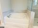 Bright bathroom featuring a soaking tub and a walk-in shower with decorative tile at 360 Hayden Cir, Woodstock, GA 30189