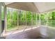 Enclosed back porch with white railings offers relaxing views of the lush green yard at 8091 Bouldercrest Pl, Douglasville, GA 30135