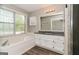 Bathroom features a soaking tub, vanity with granite counters, and updated flooring at 8091 Bouldercrest Pl, Douglasville, GA 30135