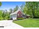 Well-maintained home showcasing architectural details, mature trees, and lush lawn on a sunny day at 8091 Bouldercrest Pl, Douglasville, GA 30135