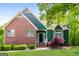 Charming home with brick accents, green siding, and well-manicured front yard, creating inviting curb appeal at 8091 Bouldercrest Pl, Douglasville, GA 30135