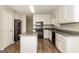 Modern kitchen featuring white cabinetry, black appliances, granite countertops, and sleek wood flooring at 8091 Bouldercrest Pl, Douglasville, GA 30135