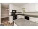 Bright kitchen showcasing white cabinets, granite counters, black appliances, and stylish wood flooring at 8091 Bouldercrest Pl, Douglasville, GA 30135