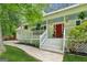 Charming home featuring a welcoming front porch, vibrant red door, and manicured landscaping at 3979 Doral Cir, Atlanta, GA 30360