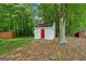 Backyard shed is painted white with a contrasting red door at 3979 Doral Cir, Atlanta, GA 30360