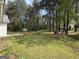 Expansive backyard with a wood deck, surrounded by mature trees, offering privacy and a serene outdoor space at 130 Elm St, Hampton, GA 30228