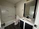 Bathroom with a toilet, sink, mirror, and tub with shower at 130 Elm St, Hampton, GA 30228