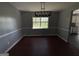 Dining room with hardwood floors, natural light, and view of kitchen at 130 Elm St, Hampton, GA 30228