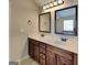 Bathroom with double sink vanity, framed mirrors, and warm wood cabinetry at 305 Mango Ct, Mcdonough, GA 30253