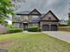 Stunning brick home featuring a manicured lawn, attached two car garage, and charming architectural details at 305 Mango Ct, Mcdonough, GA 30253