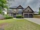 Charming two-story brick home with a well-maintained lawn and two-car garage at 305 Mango Ct, Mcdonough, GA 30253