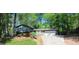 Home featuring a brick and siding exterior, complemented by a two-car garage and lush surrounding trees at 644 Garden Grove Dr, Lawrenceville, GA 30044