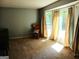 Inviting living room with a large window, carpet, and a chair with sunlight shining through at 644 Garden Grove Dr, Lawrenceville, GA 30044