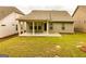 View of the backyard area showcasing the home's lawn and covered patio with neutral siding at 444 Silverbell Ct, Peachtree City, GA 30269