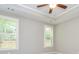 A beige bedroom with a ceiling fan and two windows with wood shutters at 444 Silverbell Ct, Peachtree City, GA 30269