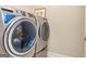 Modern laundry room featuring a front-loading washer and dryer and decor at 444 Silverbell Ct, Peachtree City, GA 30269