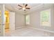 Main bedroom with carpet, tray ceiling, and a view into the main bathroom at 444 Silverbell Ct, Peachtree City, GA 30269