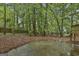 Landscaped backyard featuring a concrete patio and surrounded by trees at 101 Longer Dr, Peachtree City, GA 30269