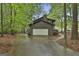 Attached two-car garage with a paved driveway and wooded surroundings at 101 Longer Dr, Peachtree City, GA 30269