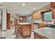 Well-lit kitchen featuring a granite-topped island with barstool seating and wooden cabinets at 101 Longer Dr, Peachtree City, GA 30269